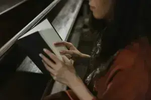 woman in orange long sleeve shirt holding white and black book