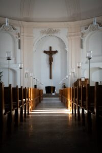 sunlit church interior with crucifix and pew