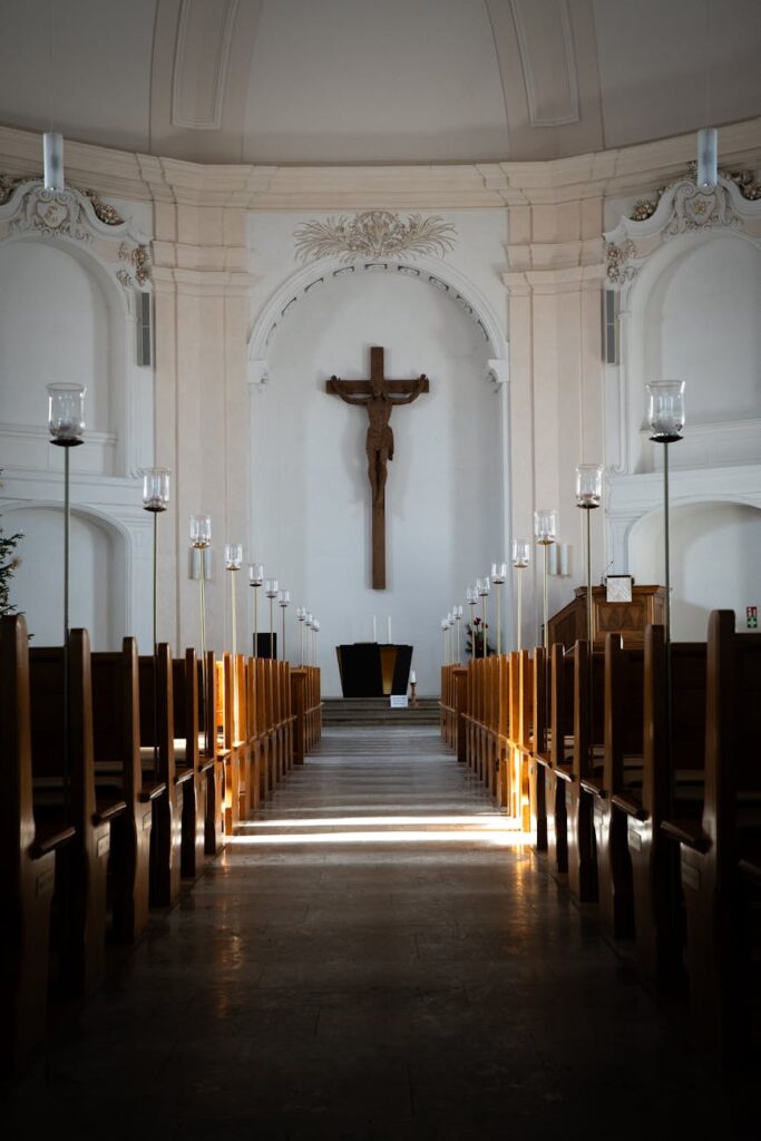 sunlit church interior with crucifix and pew