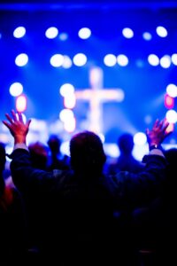 worship ceremony with raised hands and cross