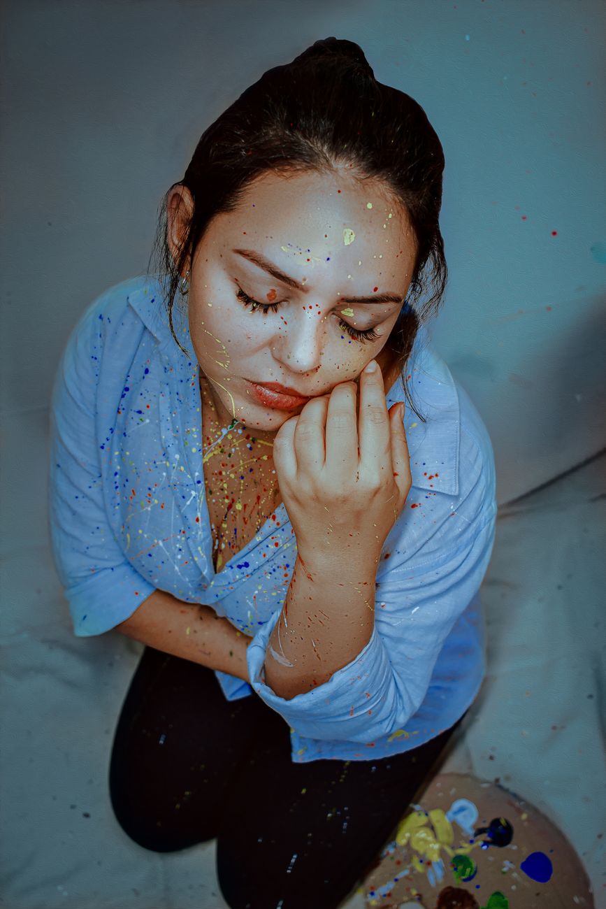 a woman in blue long sleeves with paint on her face
